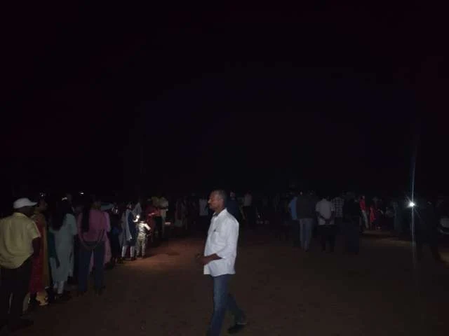 People waiting outdoors after dark during the community observing event