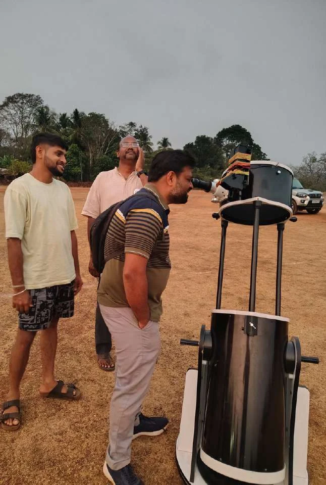 A visitor looks through a Dobsonian telescope at the HONTARA observing event